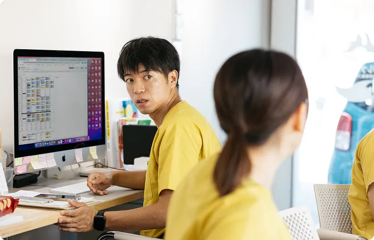 デスクトップPCでスケジュールを確認中の作業中の男性のクローズアップ。