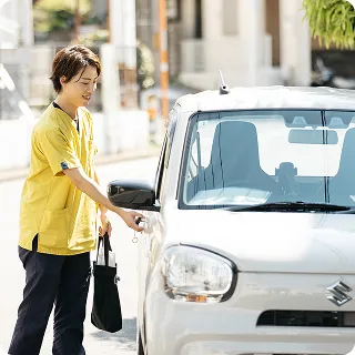 訪問介護のために社用車へ向かうスタッフの様子