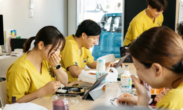 事務所で昼食をとりながら談笑する訪問看護スタッフたちの様子