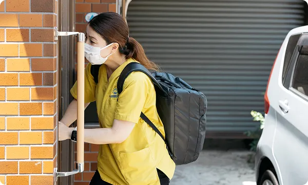 訪問看護の業務で利用者宅の玄関に向かうスタッフの様子