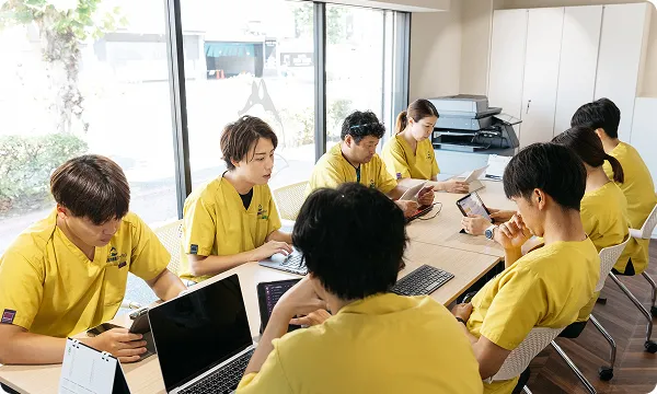 訪問看護ステーションでミーティングや記録作業を行うスタッフたち