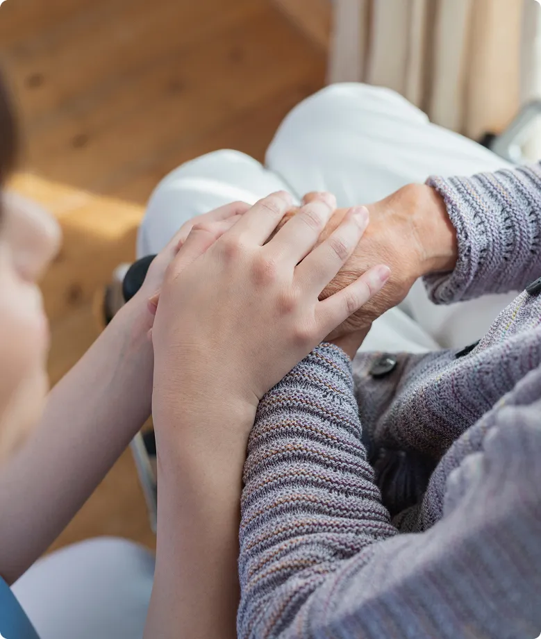 介護者が高齢者の手を温かく支え、信頼と安心感を伝える瞬間。