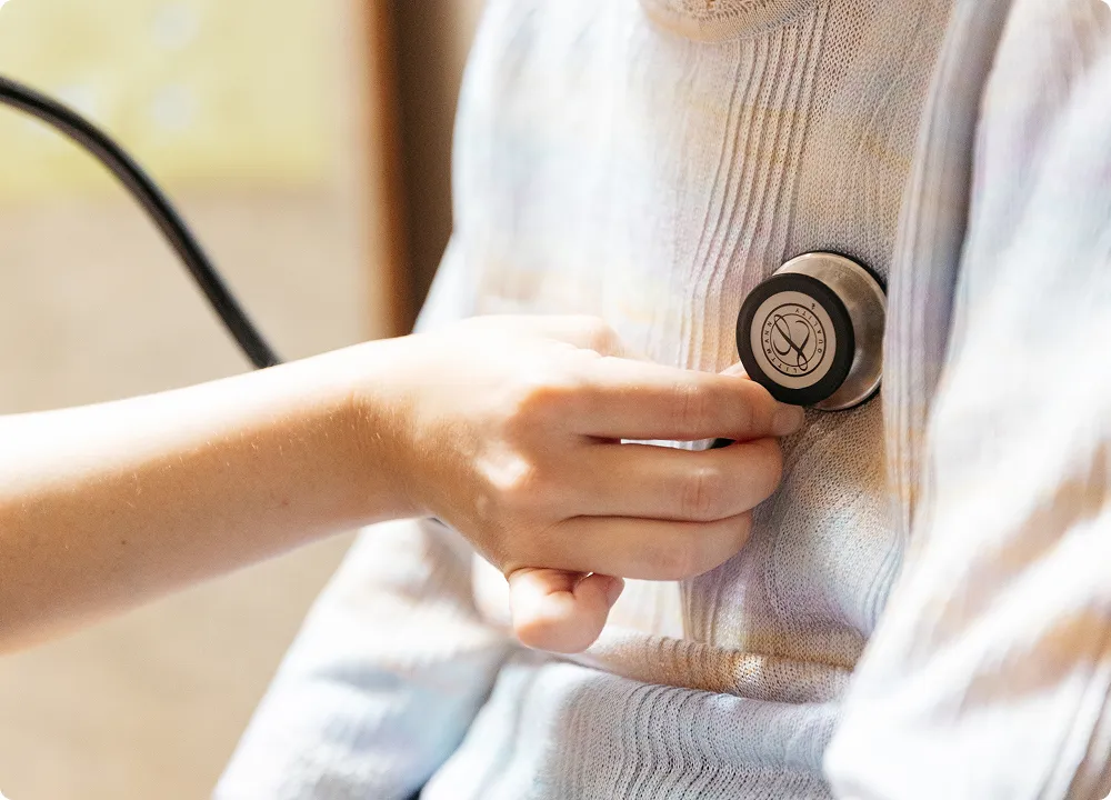 薄手のセーター越しに伝わる、医療従事者の優しい手の温もり。