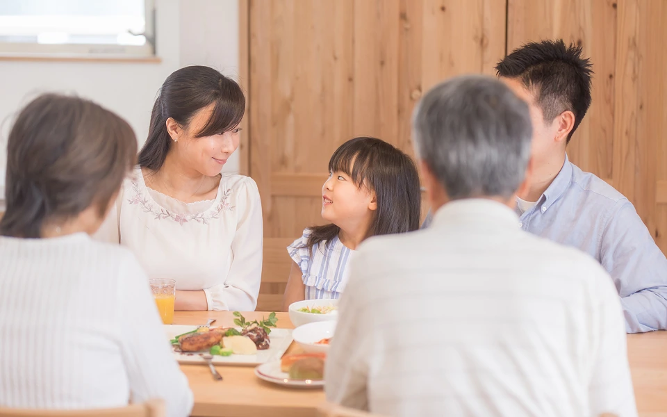 食卓を囲む三世代家族の笑顔、温かい午後のひととき。