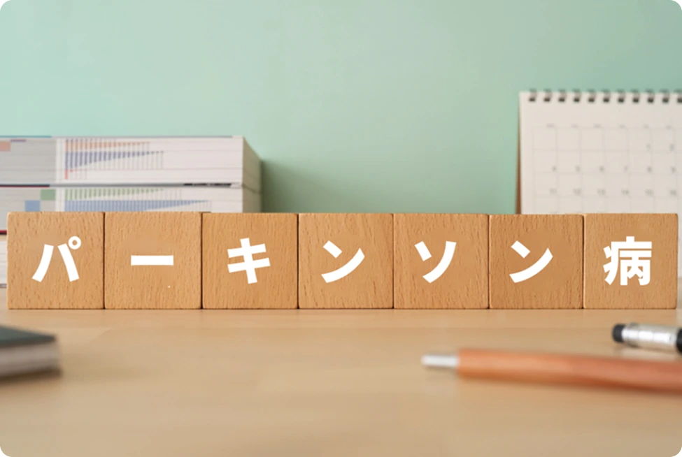 木製ブロックに「パーキンソン病」の文字。静かながらも真剣なテーマを提示。